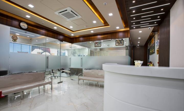 The waiting area beside the curved reception desk, with a marble floor and warm lighting